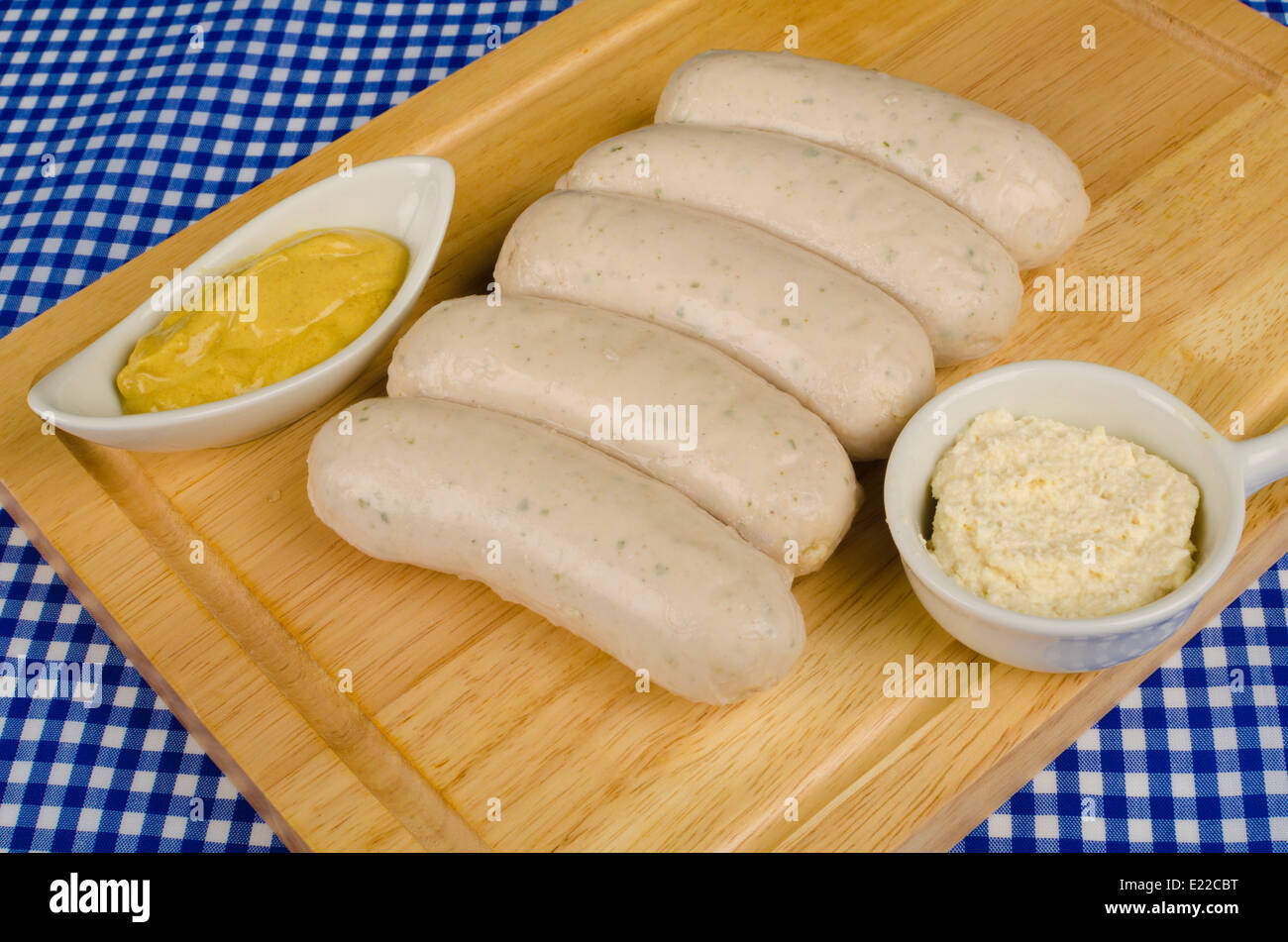 Raw sausages on a chopping board with some ingredients Stock Photo
