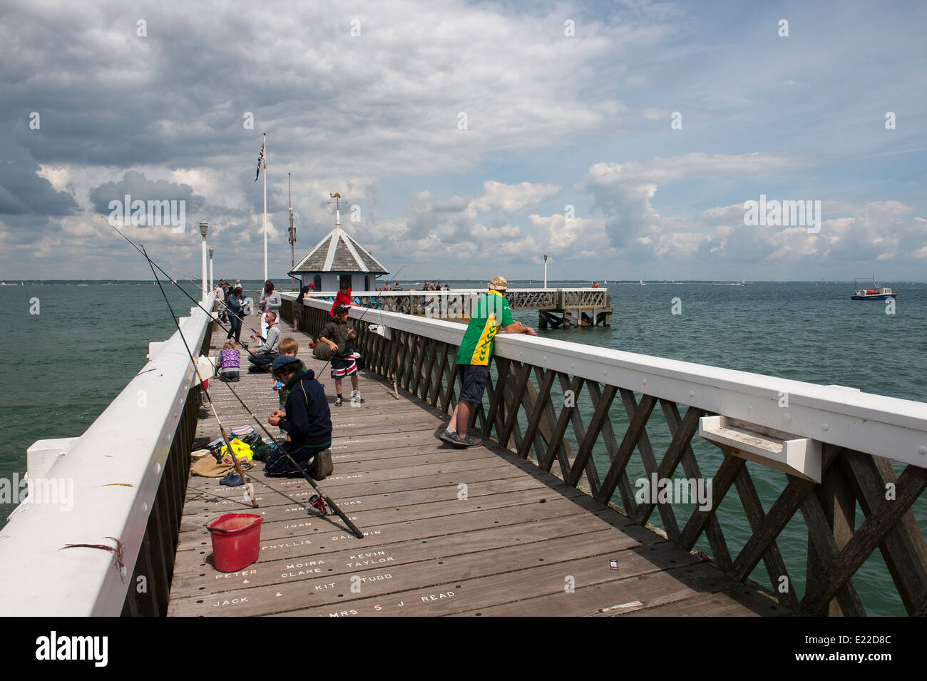 Families fishing off of Yarmouth pier on the Isle of Wight, England. Stock Photo