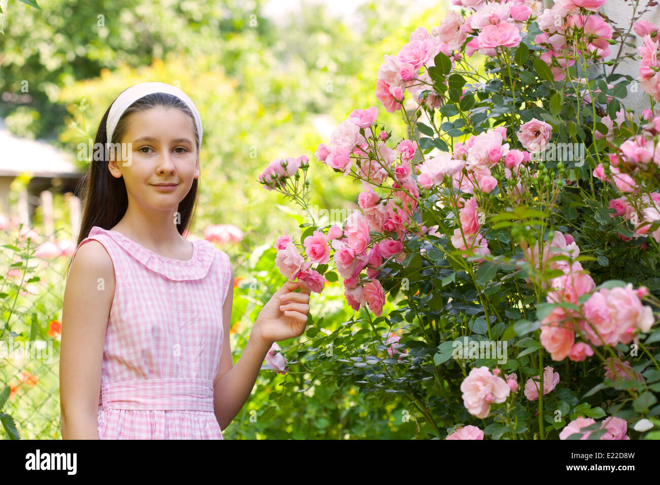 Teenage girl in the country garden with blooming rose bush Stock Photo ...
