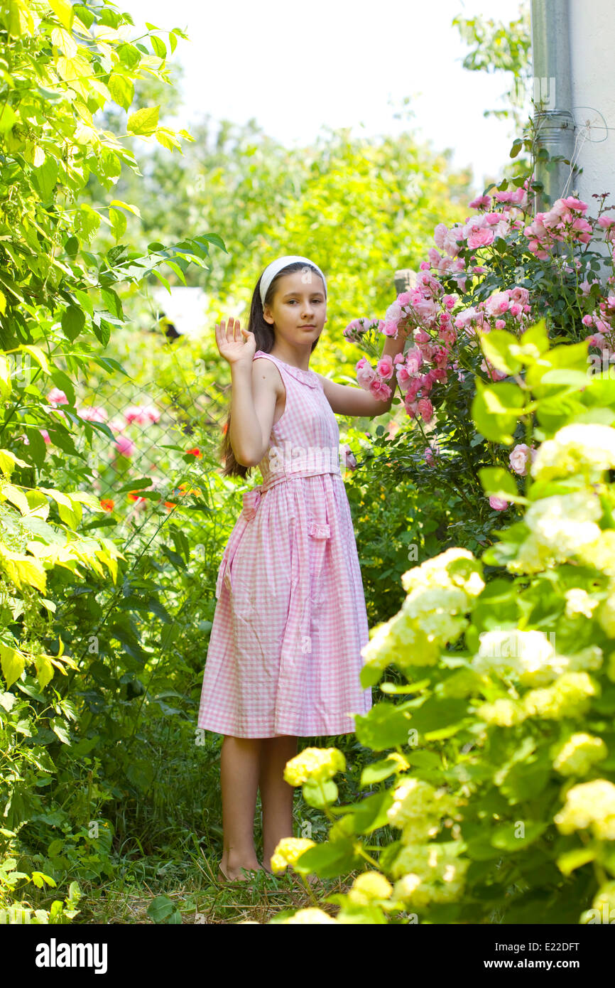 Teenage girl in the country garden with blooming rose bush Stock Photo ...