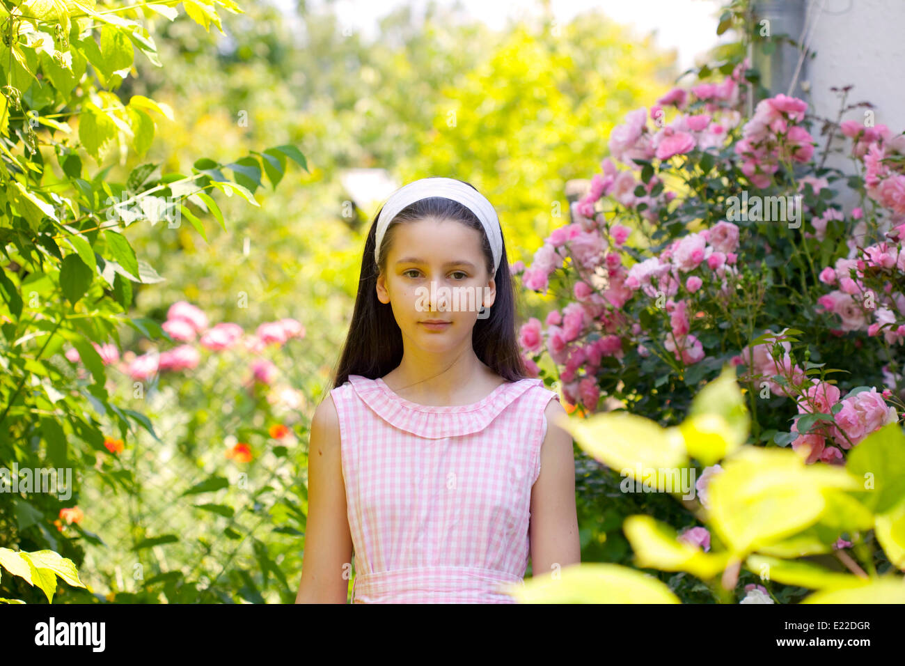 Teenage girl in the country garden with blooming rose bush Stock Photo ...