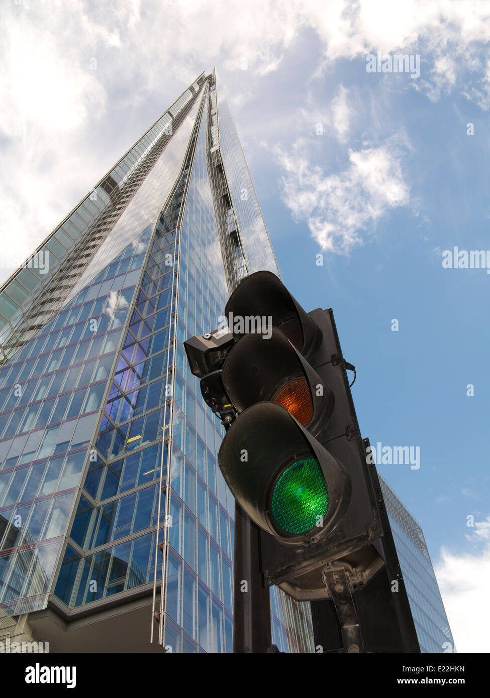 A wide angle of The London Shard against a dramatic blue and white sky with traffic light in foreground showing green for go Stock Photo