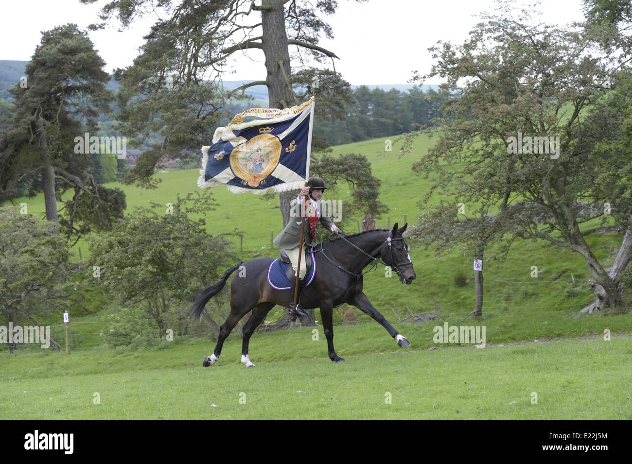 Selkirk, Scotland UK. 13 June 2014 Selkirk Common Riding 2014 The Royal Burgh of Selkirk, in the Scottish Borders celebrates its traditions and commemorates its history. Greg MacDougall , Royal Burgh Standard Bearer leads his mounted followers, over 300, out from the Linglie to ride the marches.   Credit:  Rob Gray/Alamy Live News Stock Photo