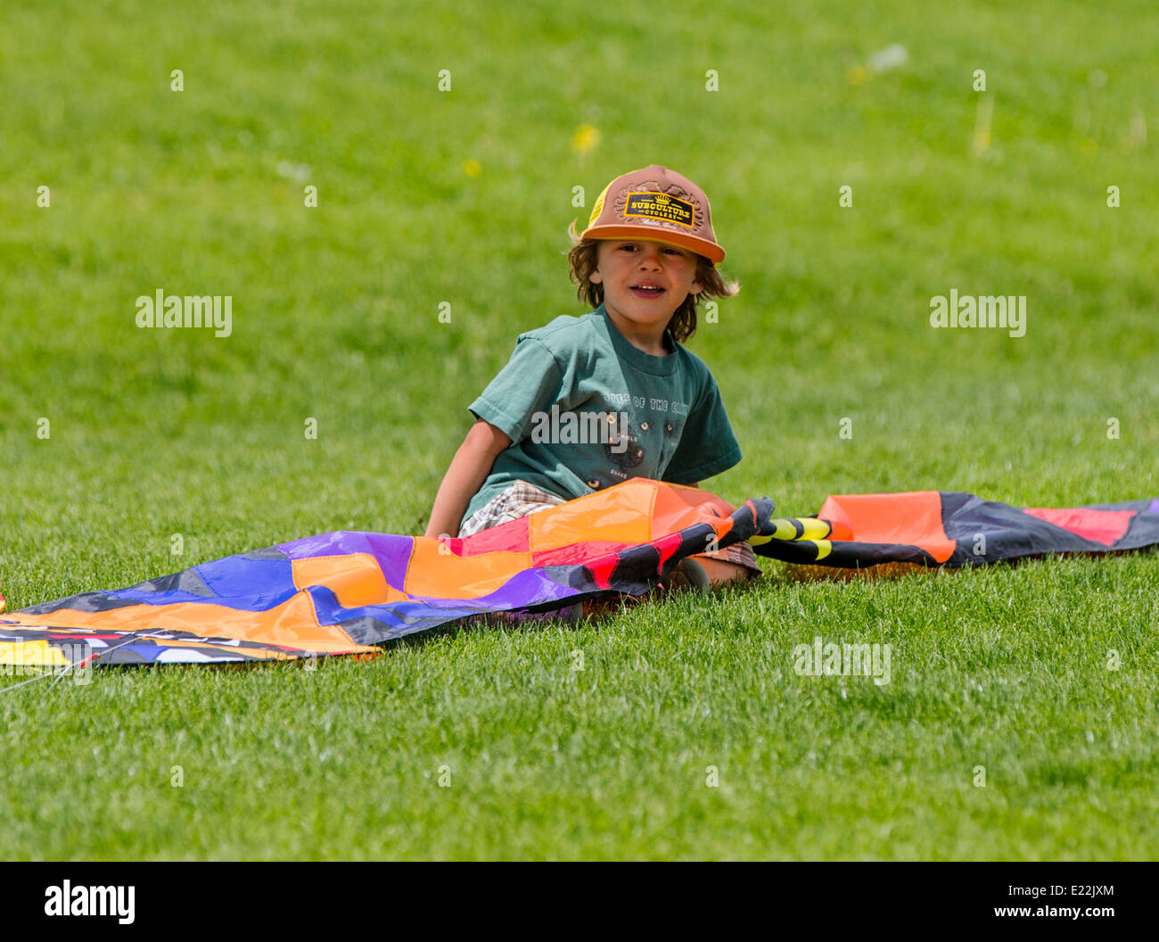 Young boy flying a kite on a grassy field Stock Photo