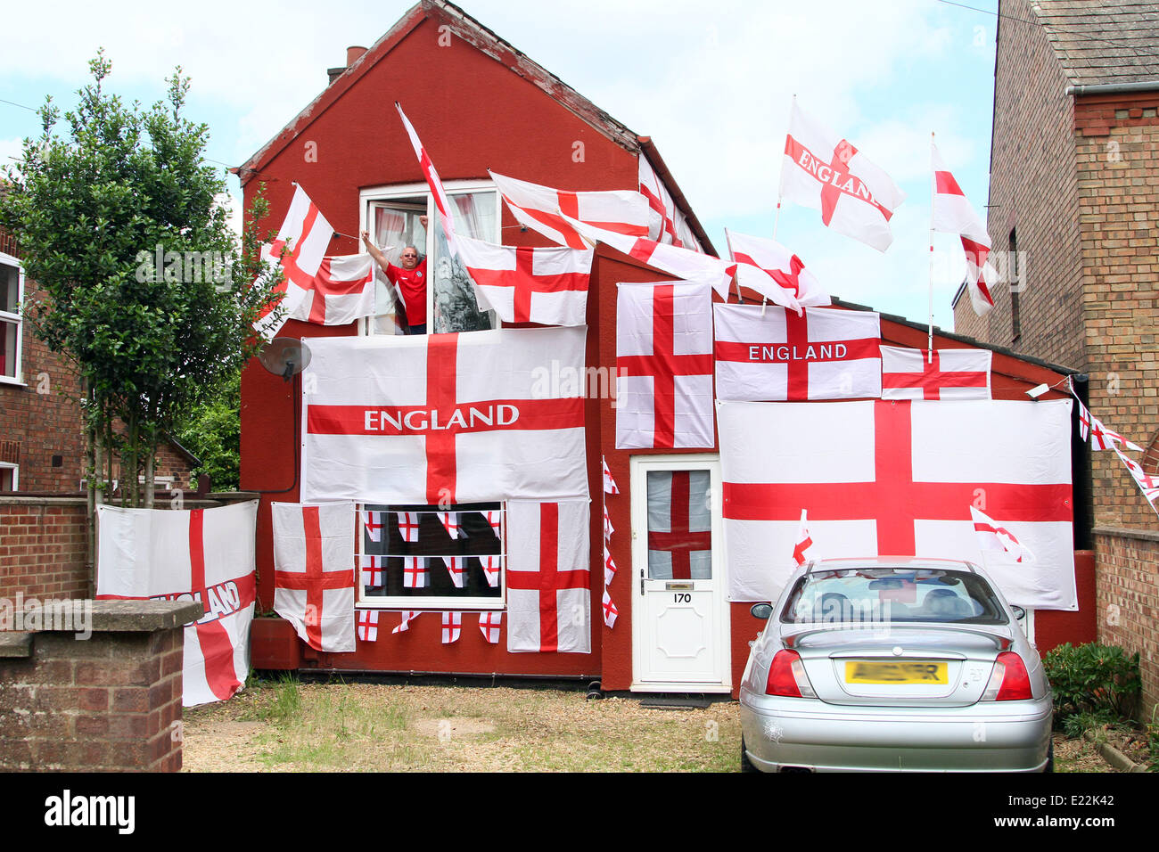 England fan . . Whittlesey, Cambridgeshire, UK . . 11.06.2014 Paul Skutela poses proudly with his house decorated in England flags, at Whittlesey, Cambridgeshire. Paul is a delivery driver and first decorated his house with flags during the 2006 World Cup and he has added more and more flags to his collection. A huge Arsenal, he is going to leave the flags in place, even if England get knocked out of the competition. Pic: Paul Marriott Photography Stock Photo