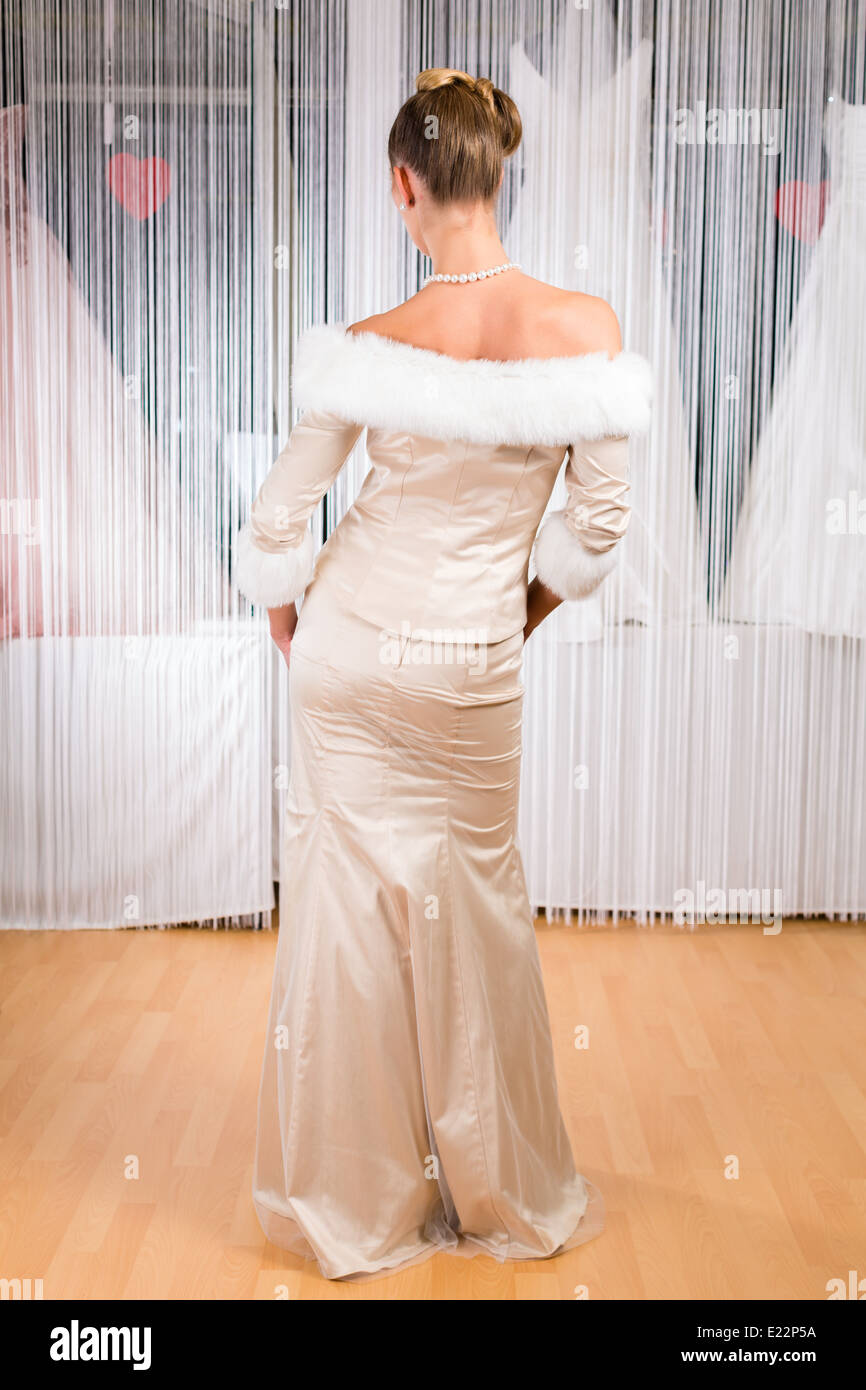 Woman trying on wedding dress or bridal gown in wedding fashion store Stock Photo