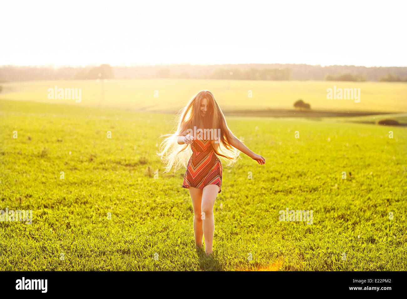 beautiful girl plays in the field at sunset Stock Photo - Alamy