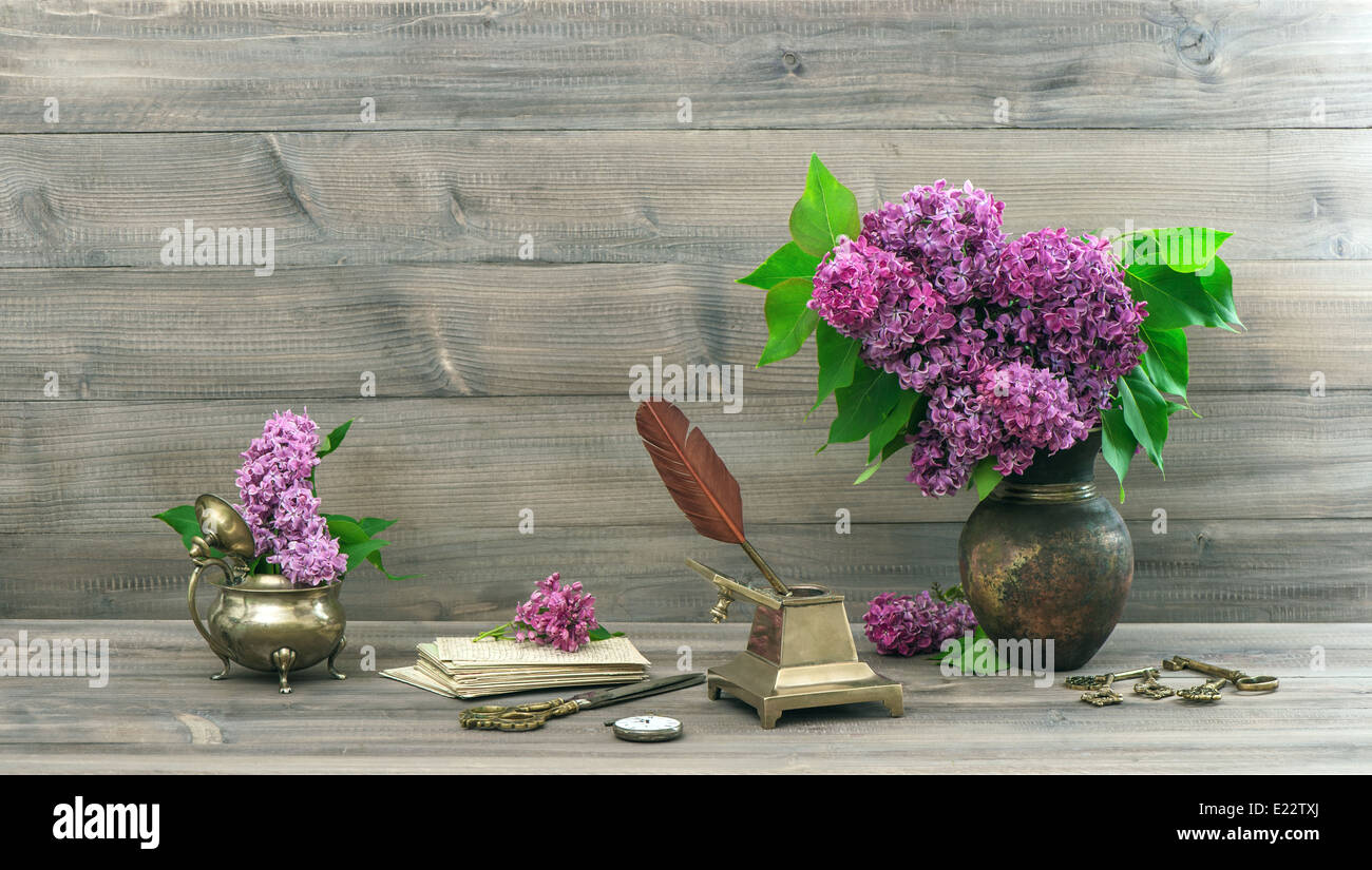 vintage still life with lilac flowers in vase on wooden background ...