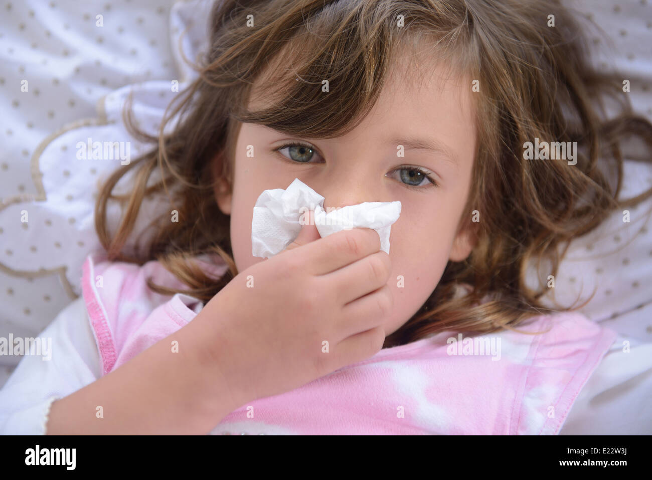 Sneezing child in bed suffering from allergy or flu Stock Photo Alamy