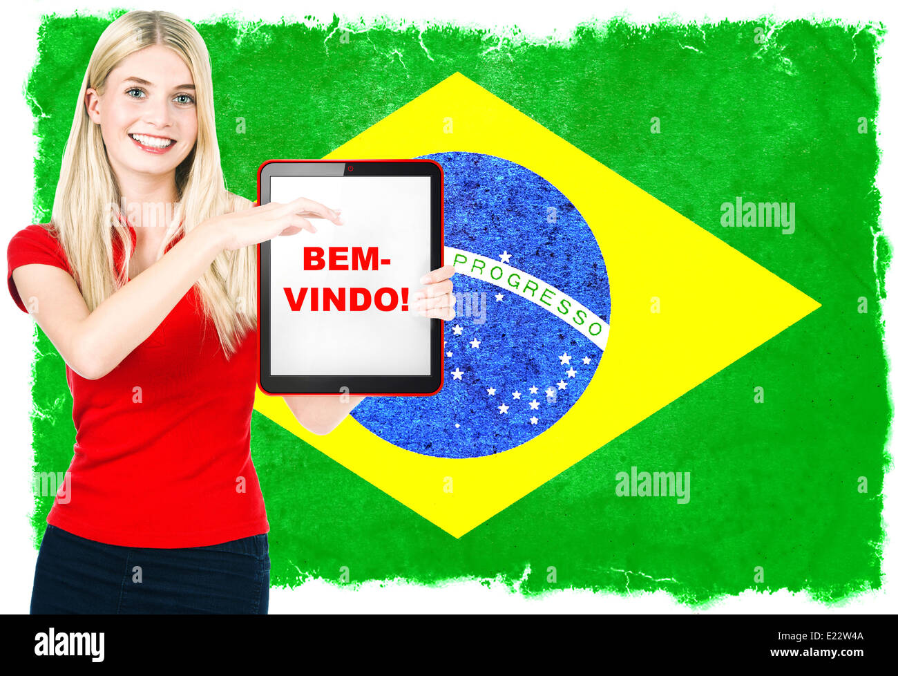 young woman with flag of brasil on the background holding tablet pc. sample text WELCOME! Stock Photo