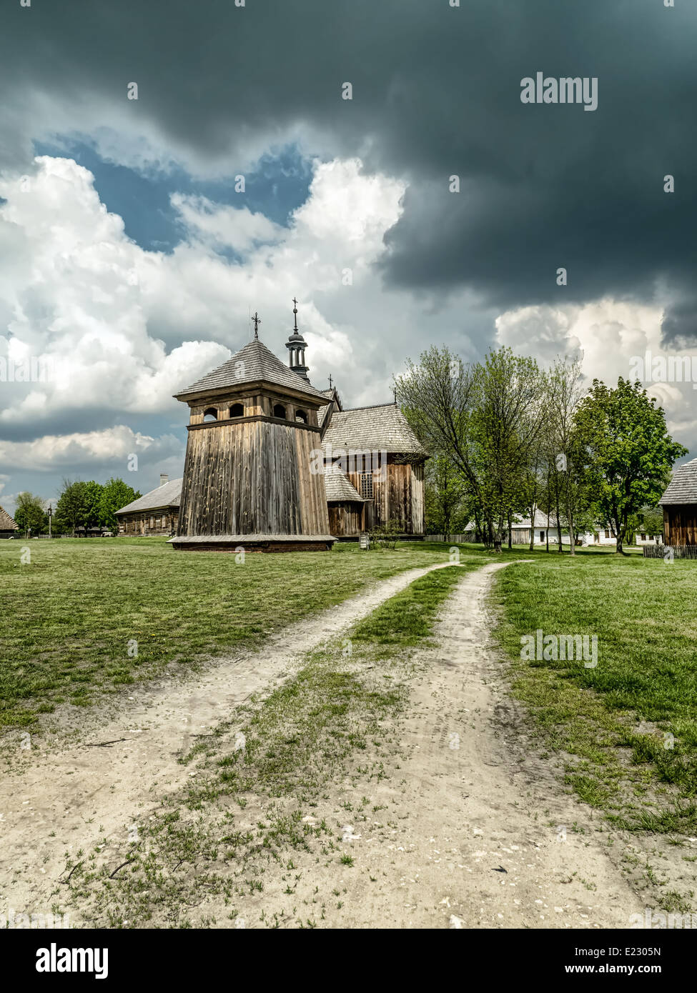 Countryside landscape with old little wooden church against dramatic sky Stock Photo