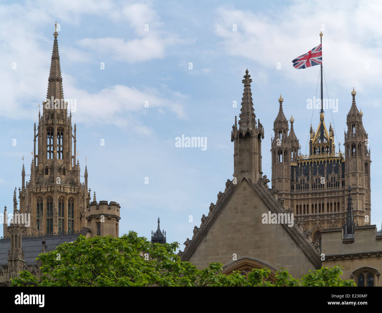 Tops of Victoria Tower flying the Union Jack and Central Tower of the Palace of Westminster London England Stock Photo