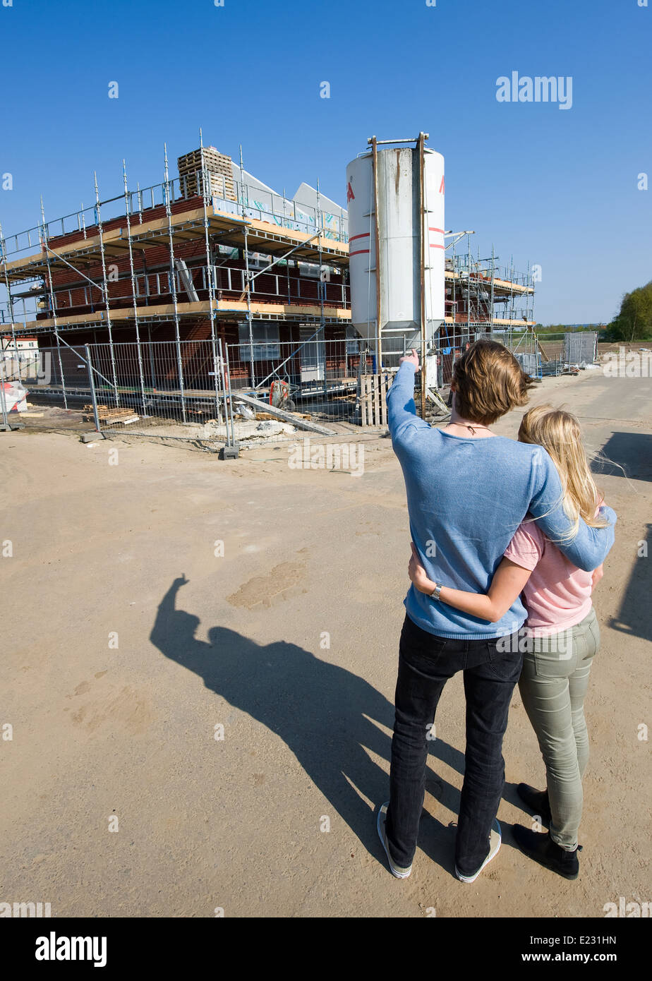 Young couple looking on construction site how their new house is being built Stock Photo