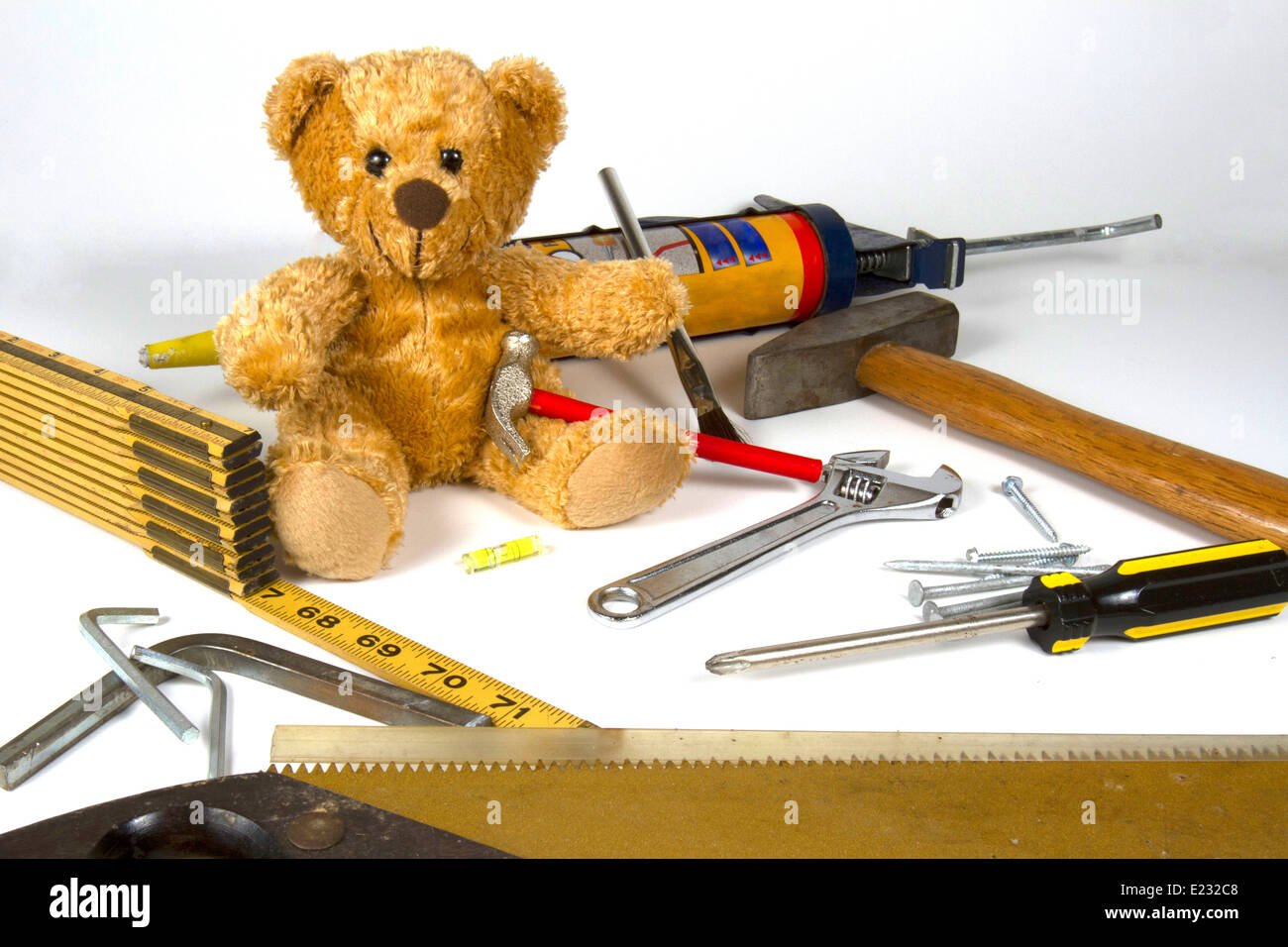 Teddy Bear sitting amid home repair, maintenance, construction tools. Stock Photo