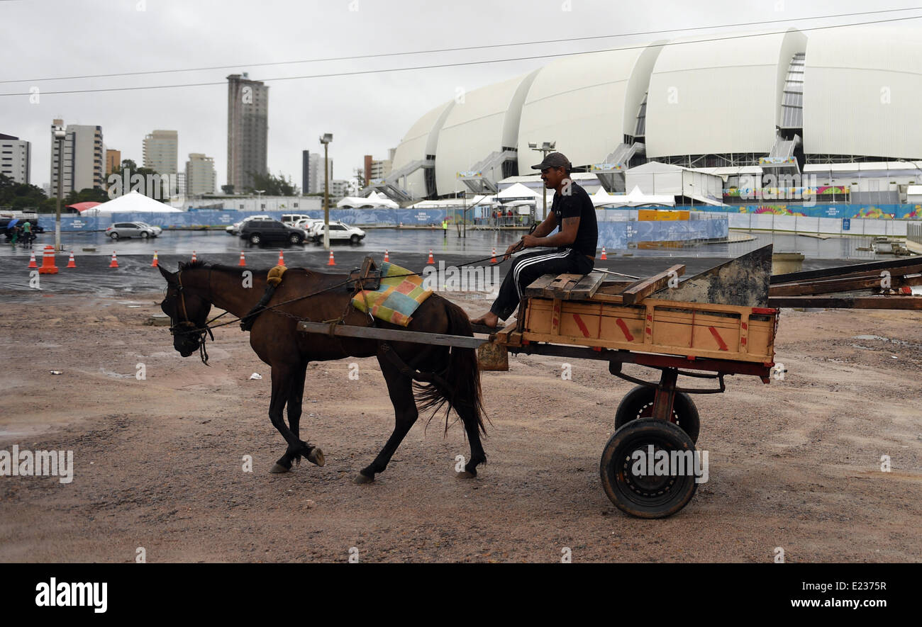 A horse cart drives past the Estadio Arena das Dunas Stadium at the FIFA World Cup 2014 in Natal, Brazil, 14 June 2014. Photo: Marius Becker/dpa Stock Photo