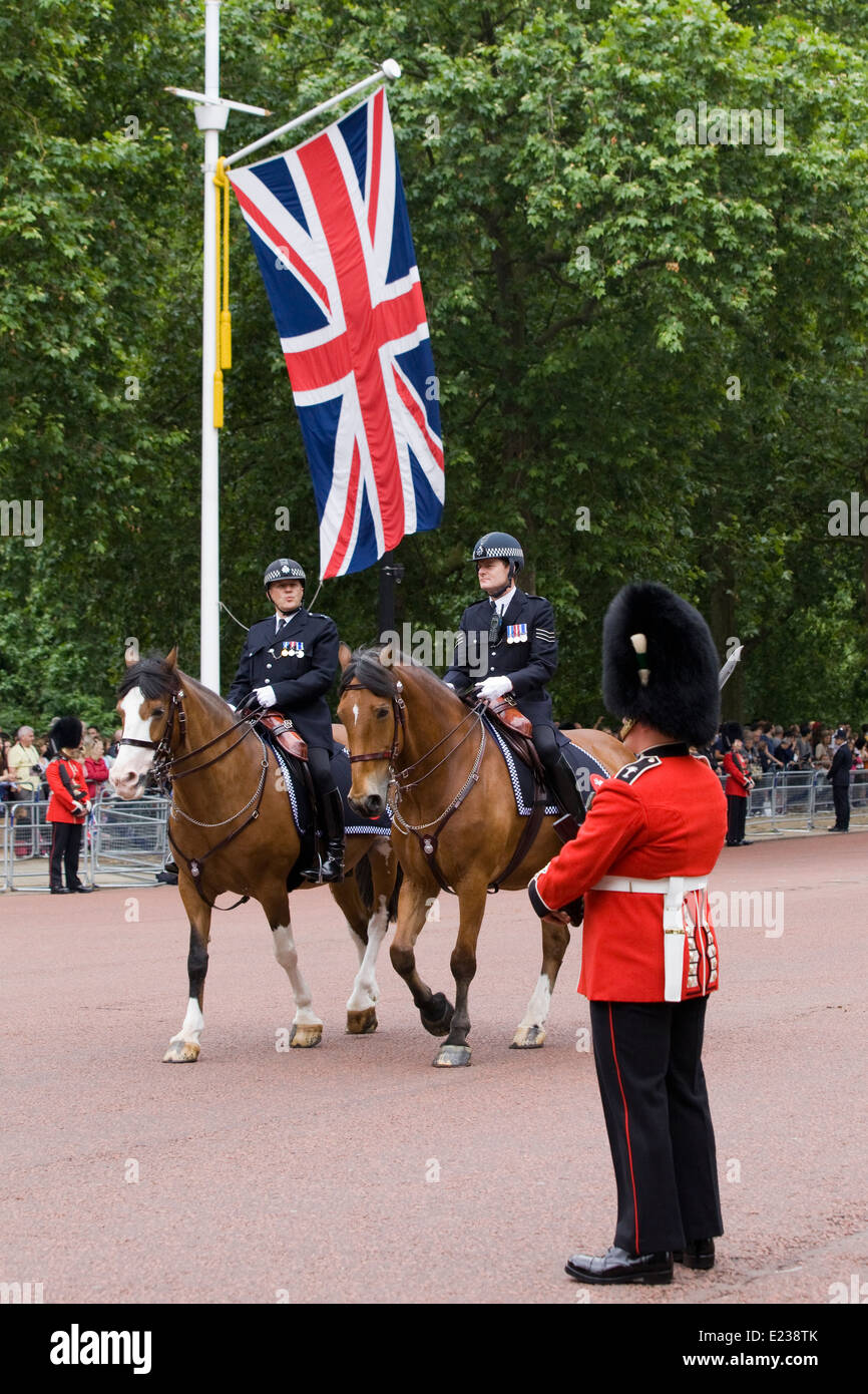 Mounted Police Officer walking past the Queens Foot guard on The Mall London England Metropolitan Police Service Stock Photo