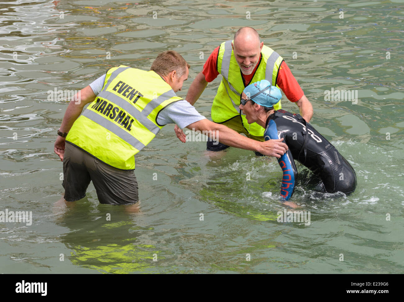 Swimmer being helped out of the river after finishing a swimming race