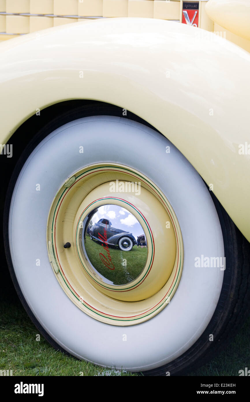 Front wing and wheel of a V8 Cadillac with a reflection of a hotrod in the wheel Stock Photo
