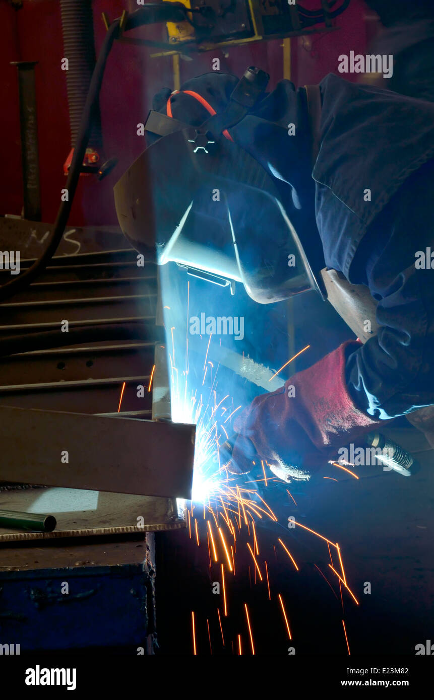 Welder with protective mask welding metal and sparks Stock Photo