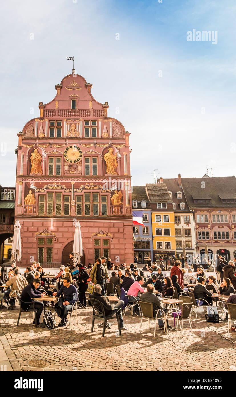 outdoor cafe at place de la reunion, in the background the renaissance facade of the former town hall, nowadays a museum Stock Photo