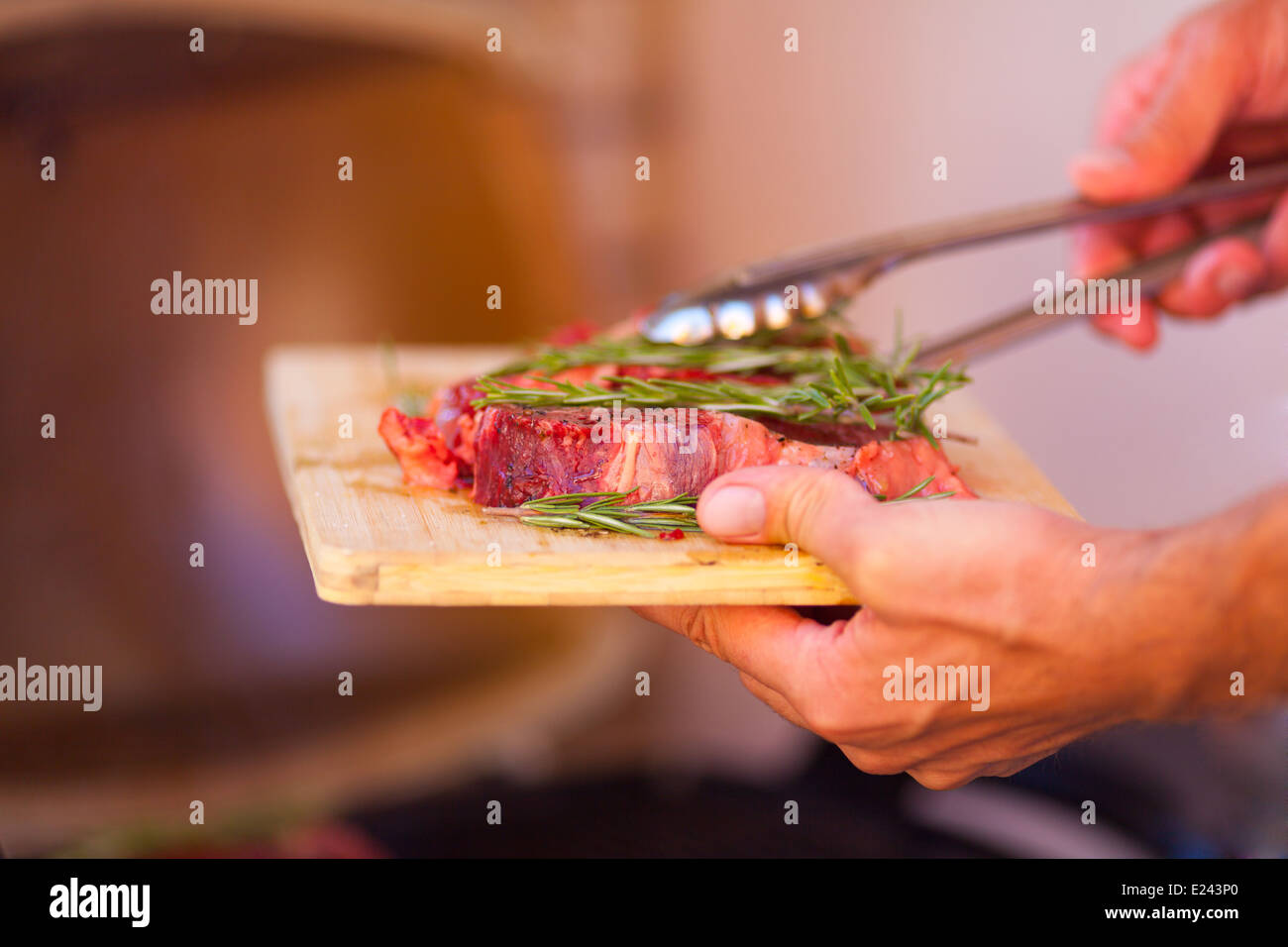 Man hands with fresh meat preparing on grill close up Stock Photo