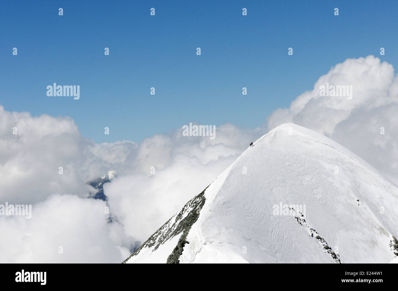 Climbers on the superb airy traverse of the Breithorn in the Swiss Alps Stock Photo