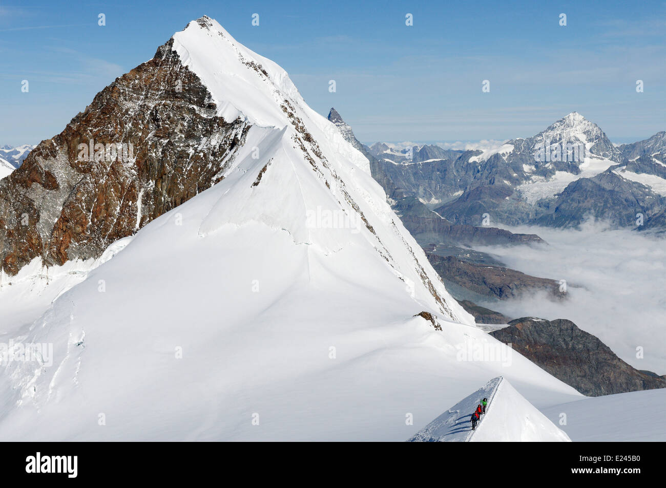 Mountaineers on a narrow ridge high on Monte Rosa, Swiss alps with the ...