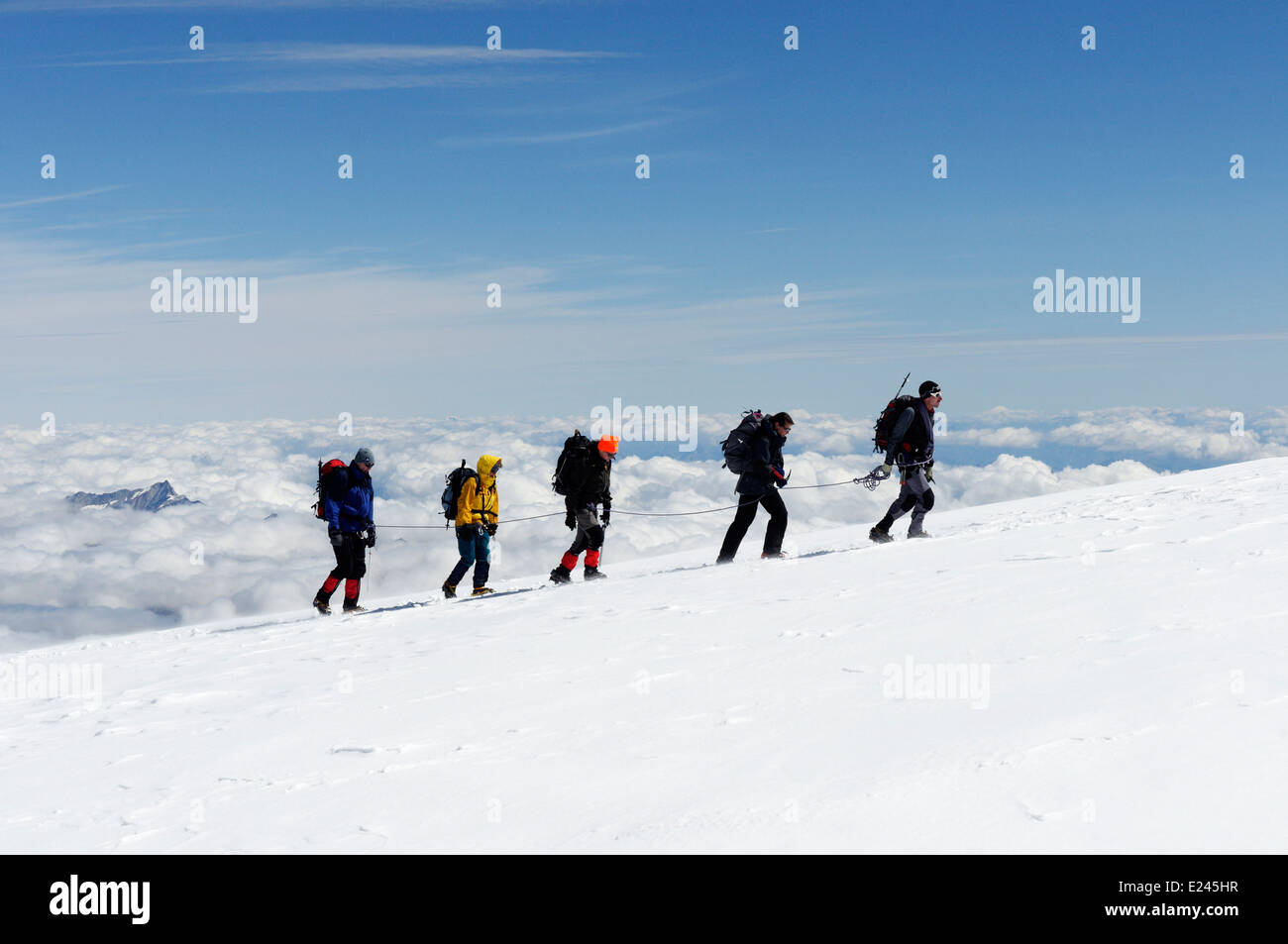 A rope of five mountaineers in the Swiss Alps Stock Photo