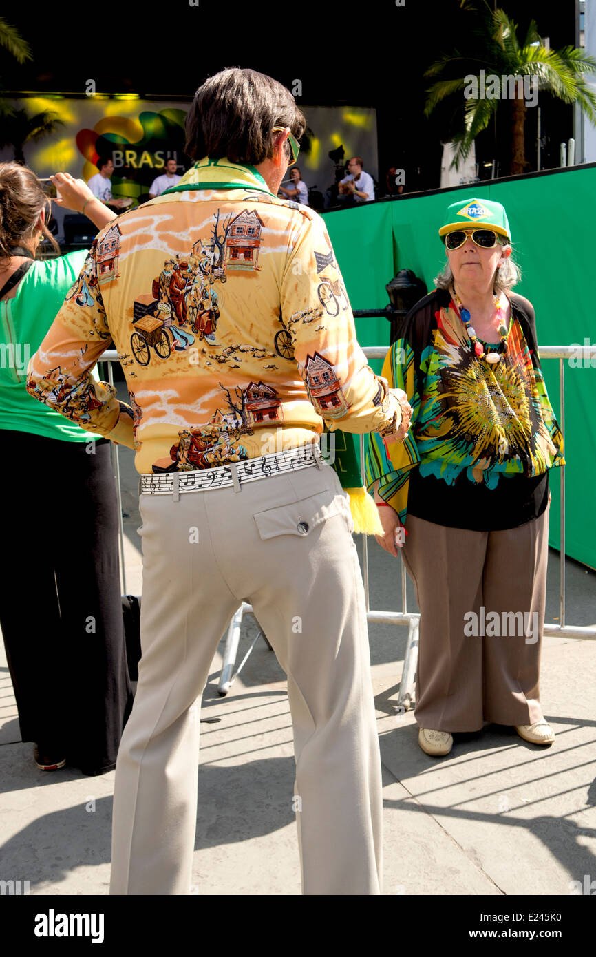 A guy dances in front of a woman at the Brazil Day celebrations in Trafalgar Square. Stock Photo