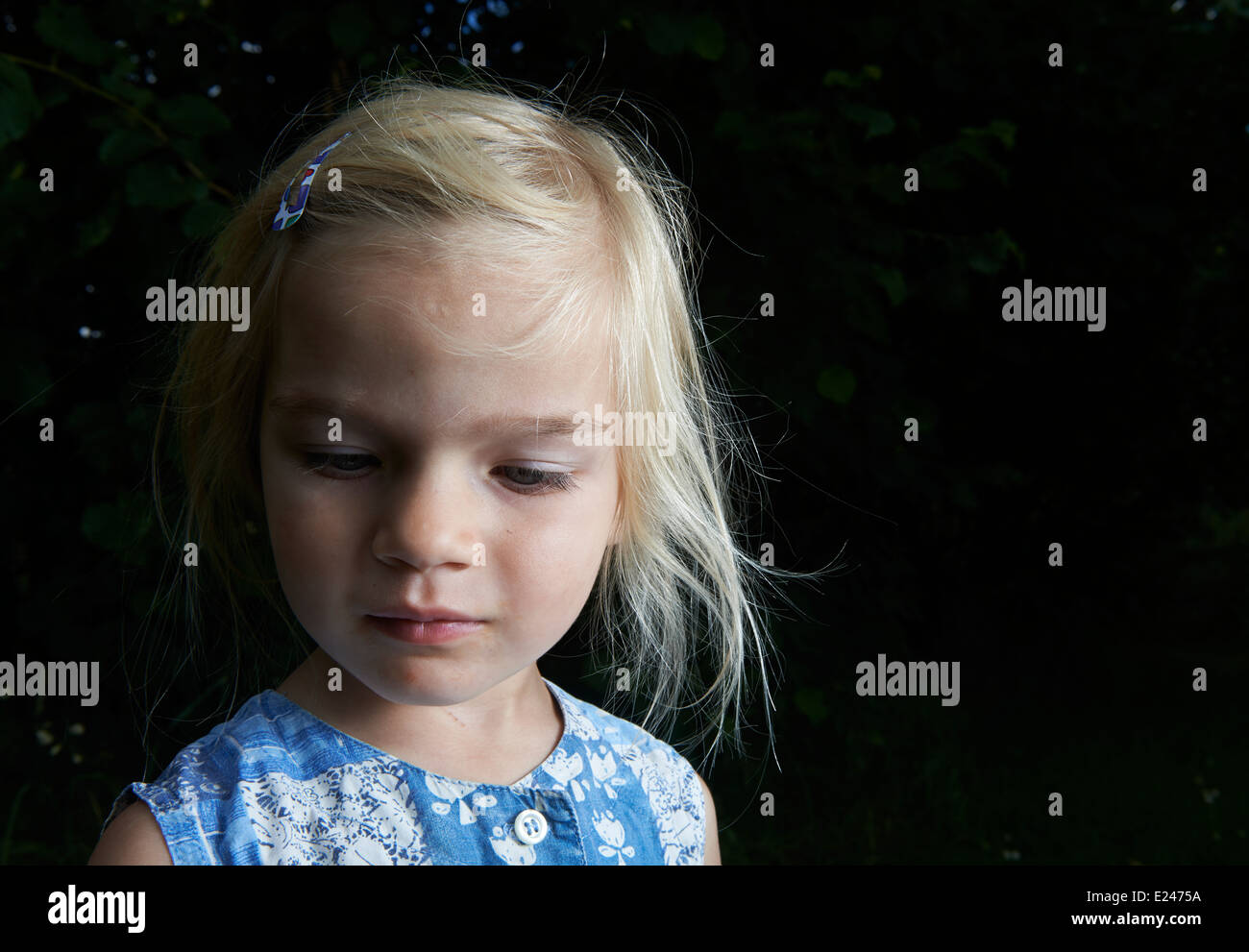 Portrait of Child Little blond girl in yard, outside in summer garden ...