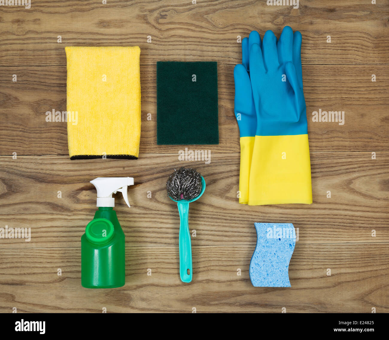 Overhead view of house cleaning materials placed on rustic wood. Stock Photo