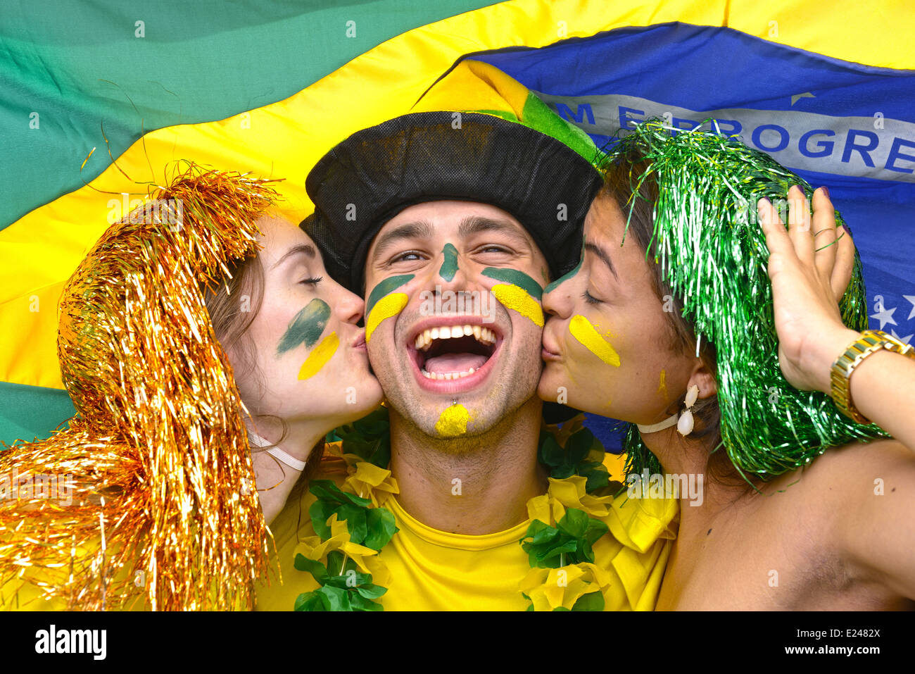 Group of happy brazilian soccer fans celebrating victory kissing each