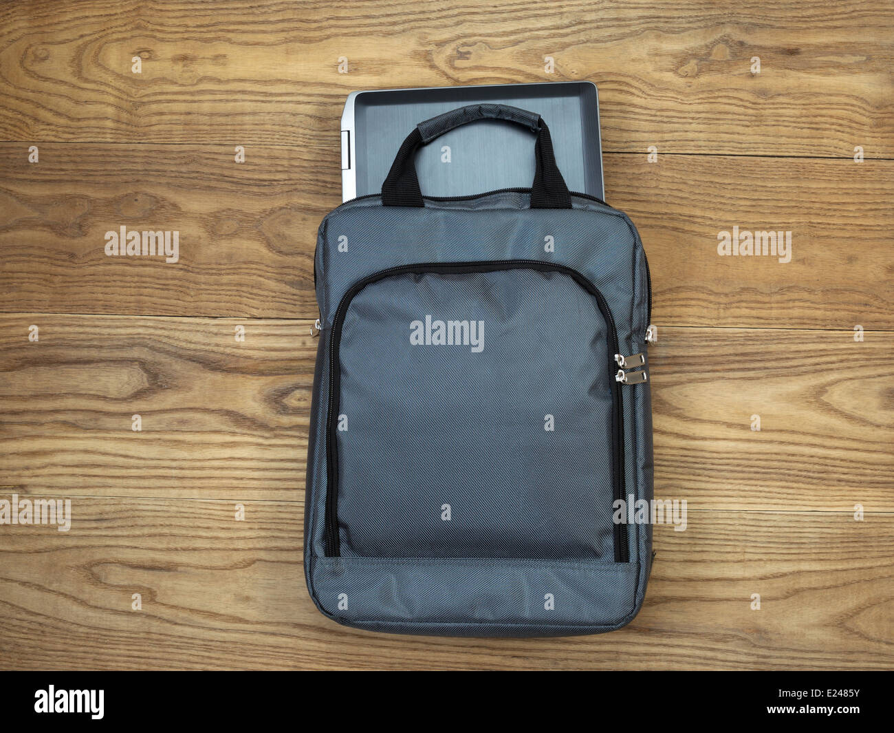 Overhead view of laptop computer, partially out of carry case, on rustic wooden boards Stock Photo