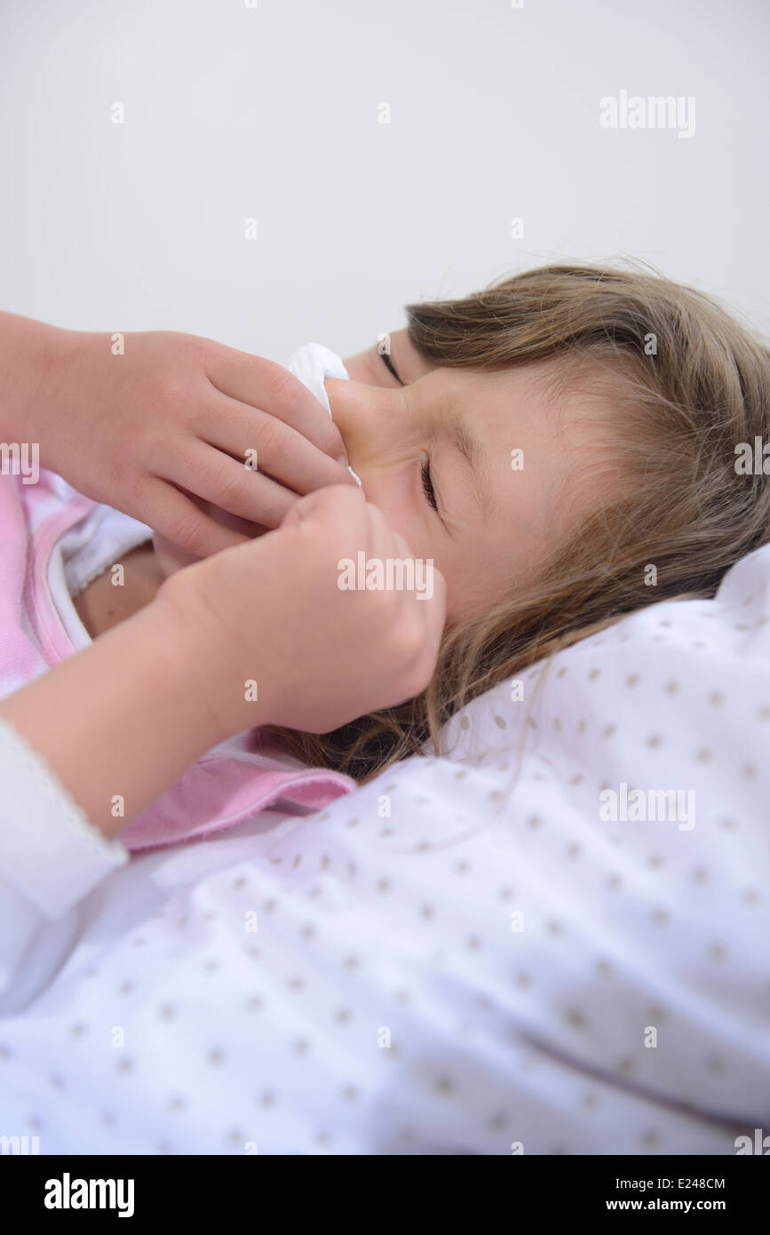 Sneezing child in bed suffering from allergy or flu Stock Photo Alamy