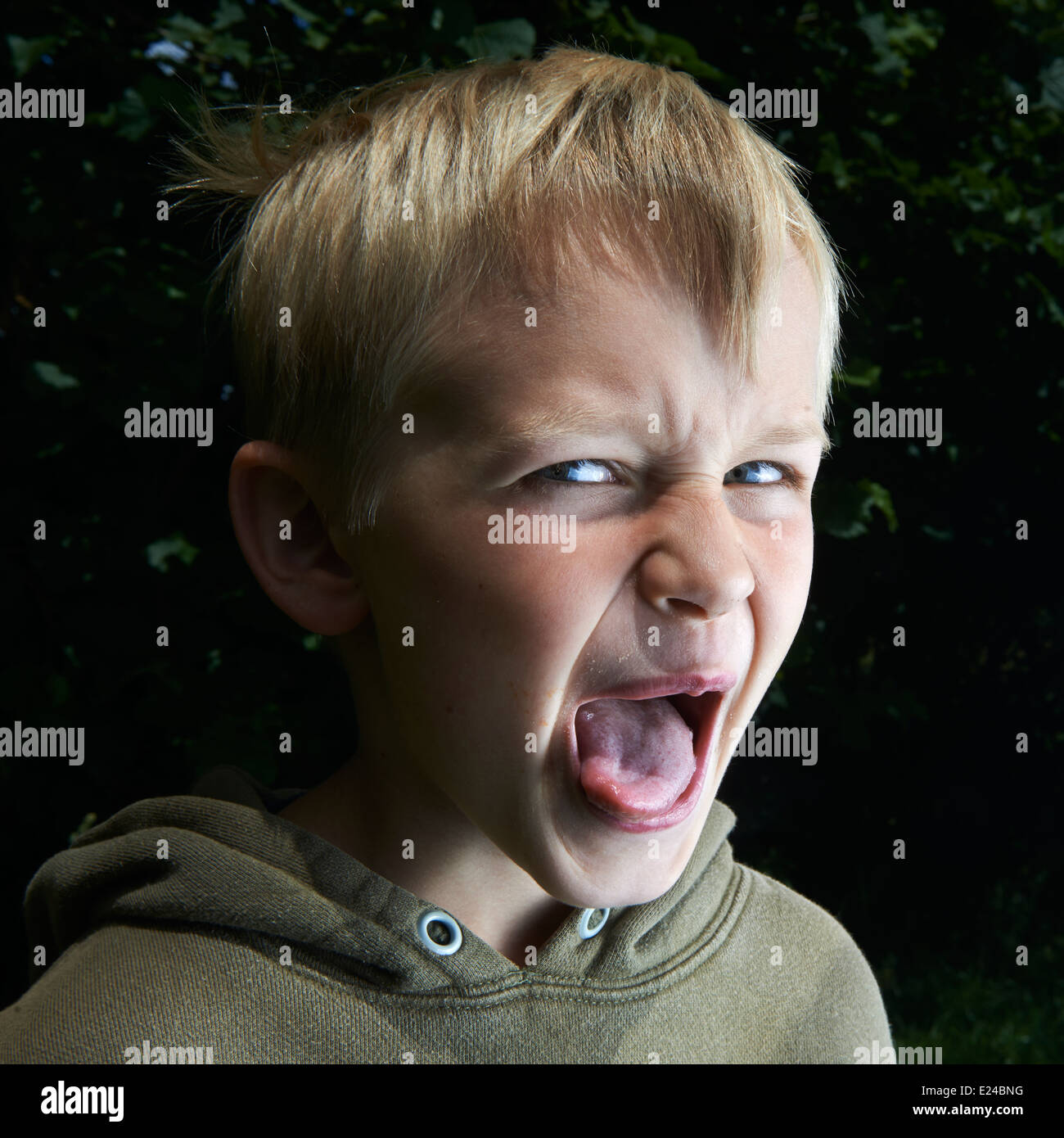 Silly young child blond boy gruesomely grimacing for camera Stock Photo