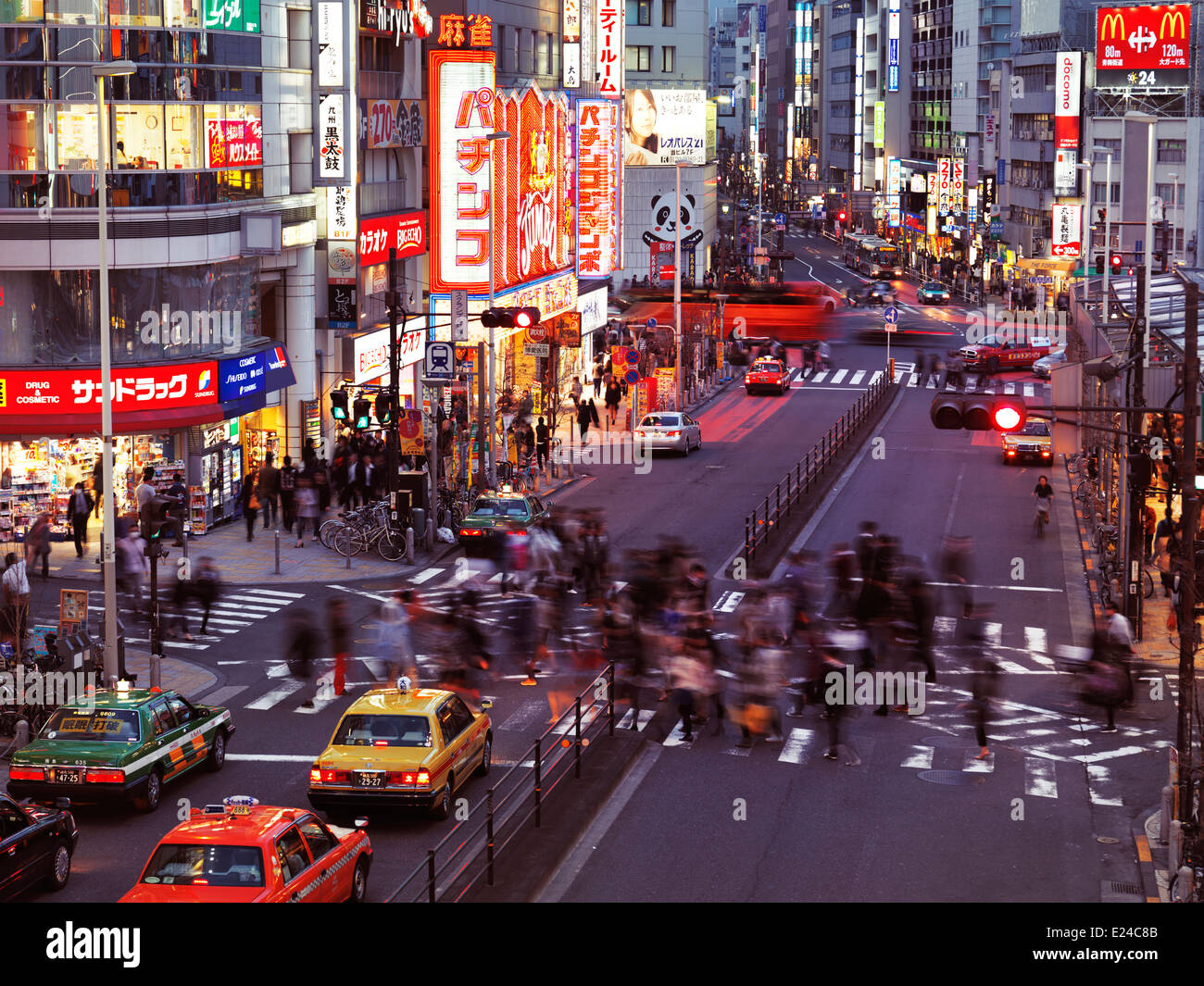 People and cars on streets in Shinjuku, Tokyo, Japan at dusk. Stock Photo