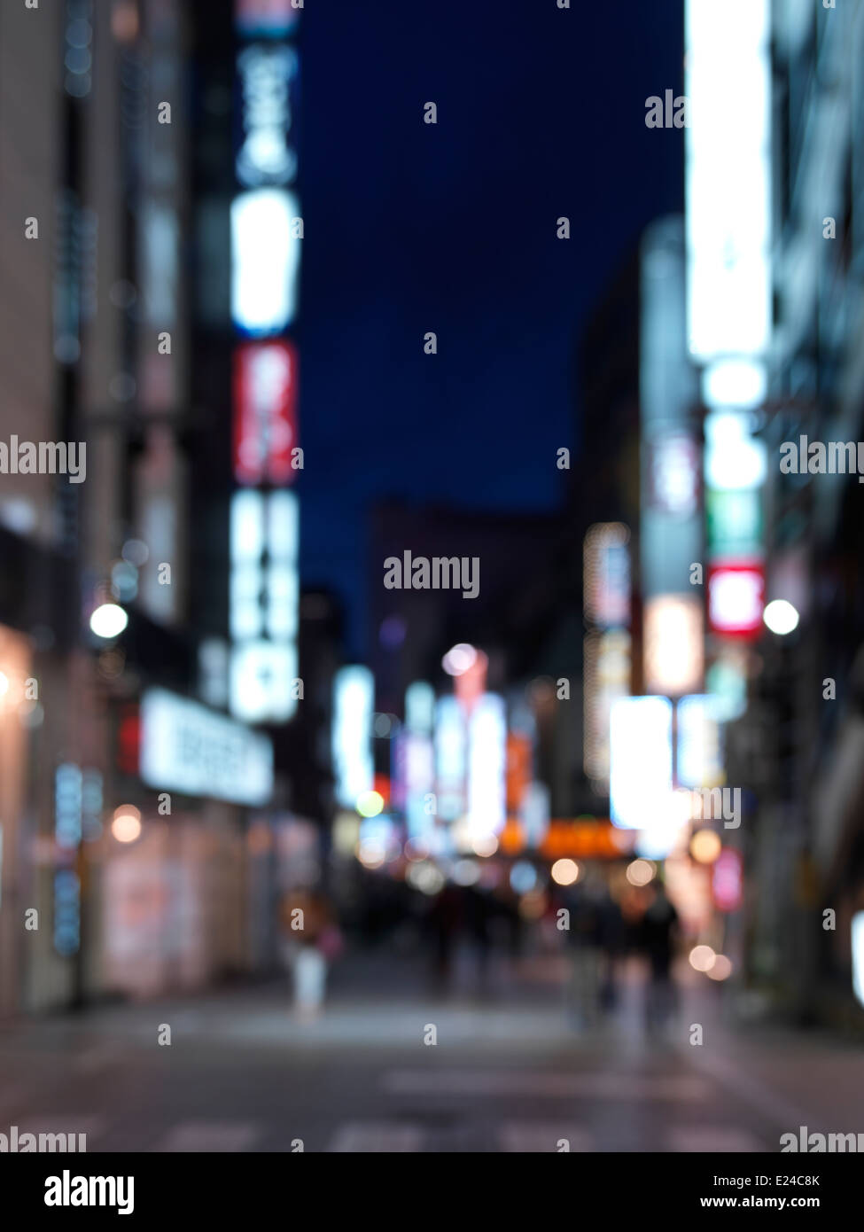 Out-of-focus street with bright signs, nighttime city scenery, Shinjuku, Tokyo, Japan. Stock Photo