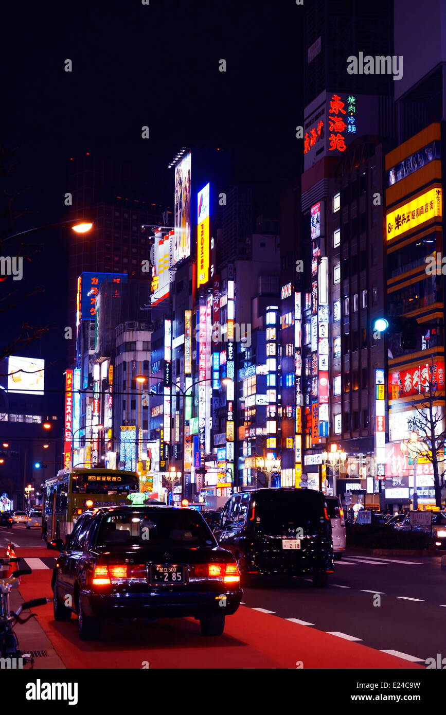 Colorful nighttime city scenery, cars and bright signs at Yasukuni Dori street, Shinjuku, Tokyo, Japan. Stock Photo