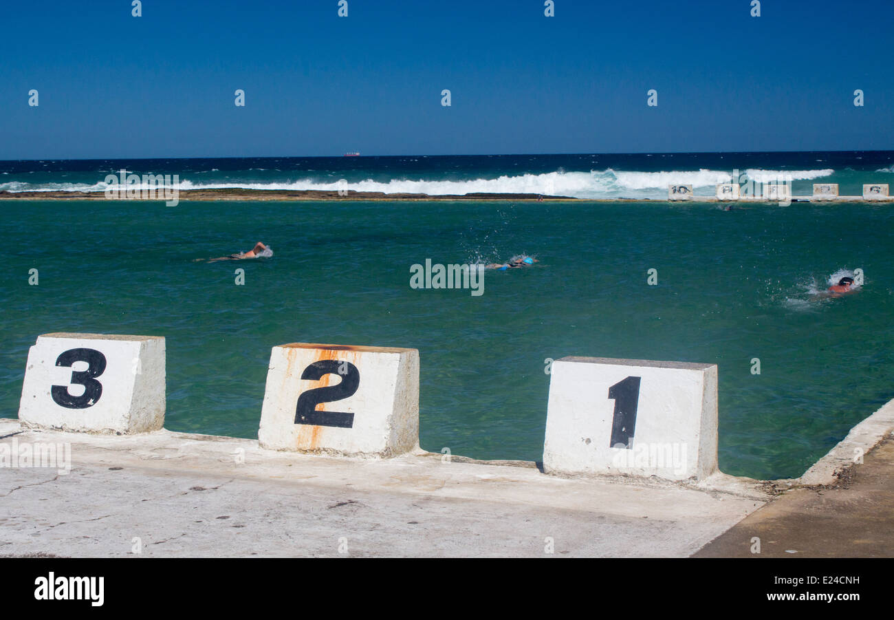 Merewether Ocean Baths Newcastle New South Wales Australia Lane markers with swimmers in swimming pool with Pacific Ocean beyond Stock Photo