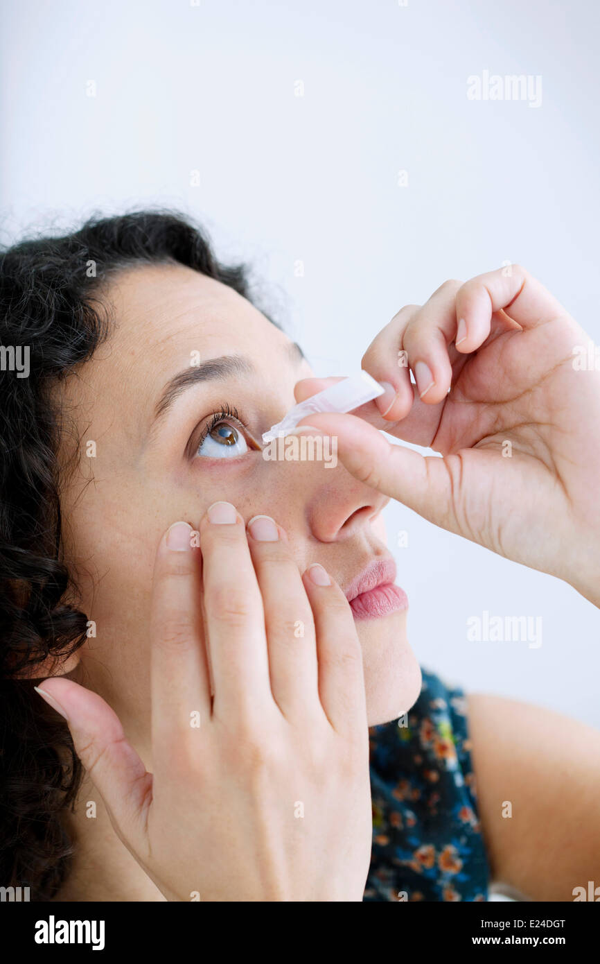 Woman using eye lotion Stock Photo