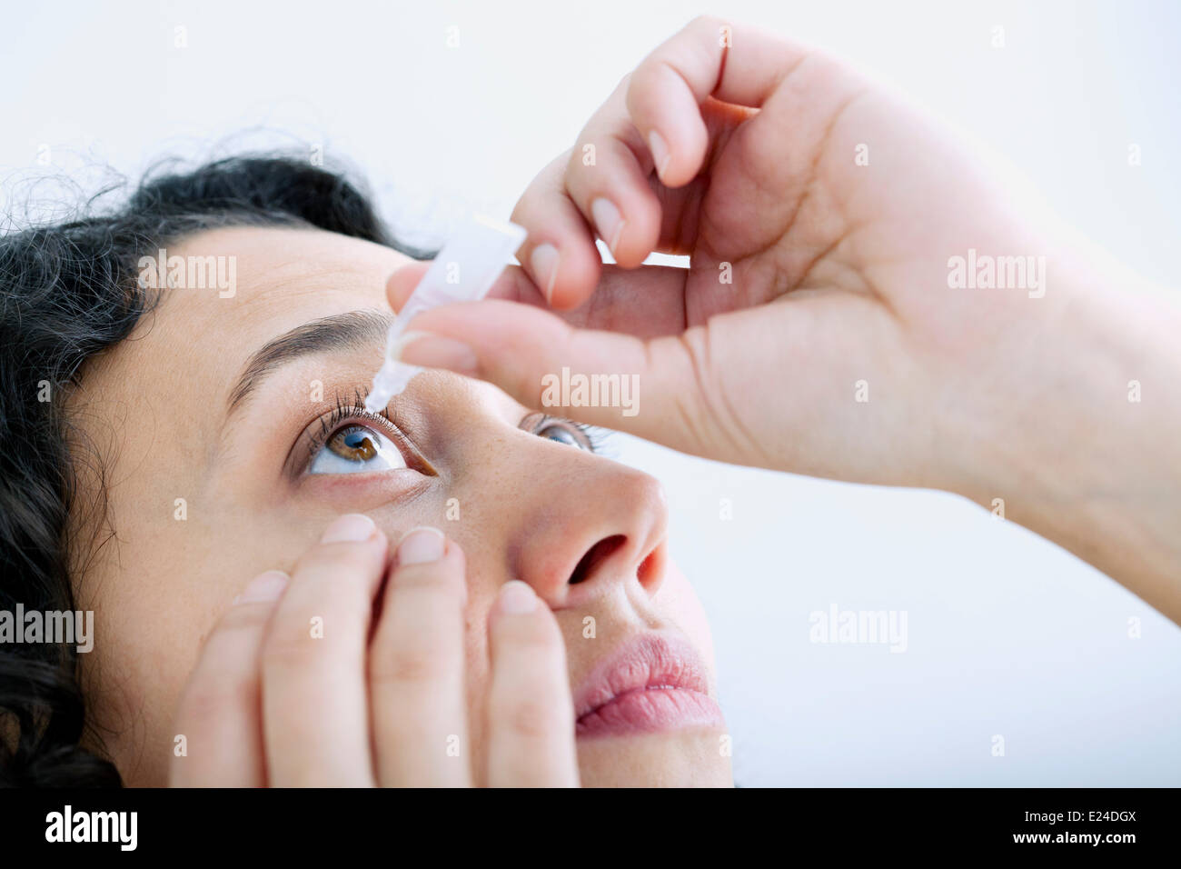 Woman using eye lotion Stock Photo
