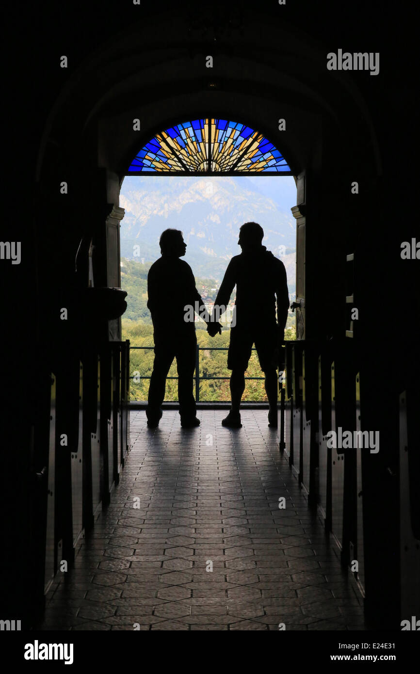 Silhouette of a gay couple to the output of church. Stock Photo