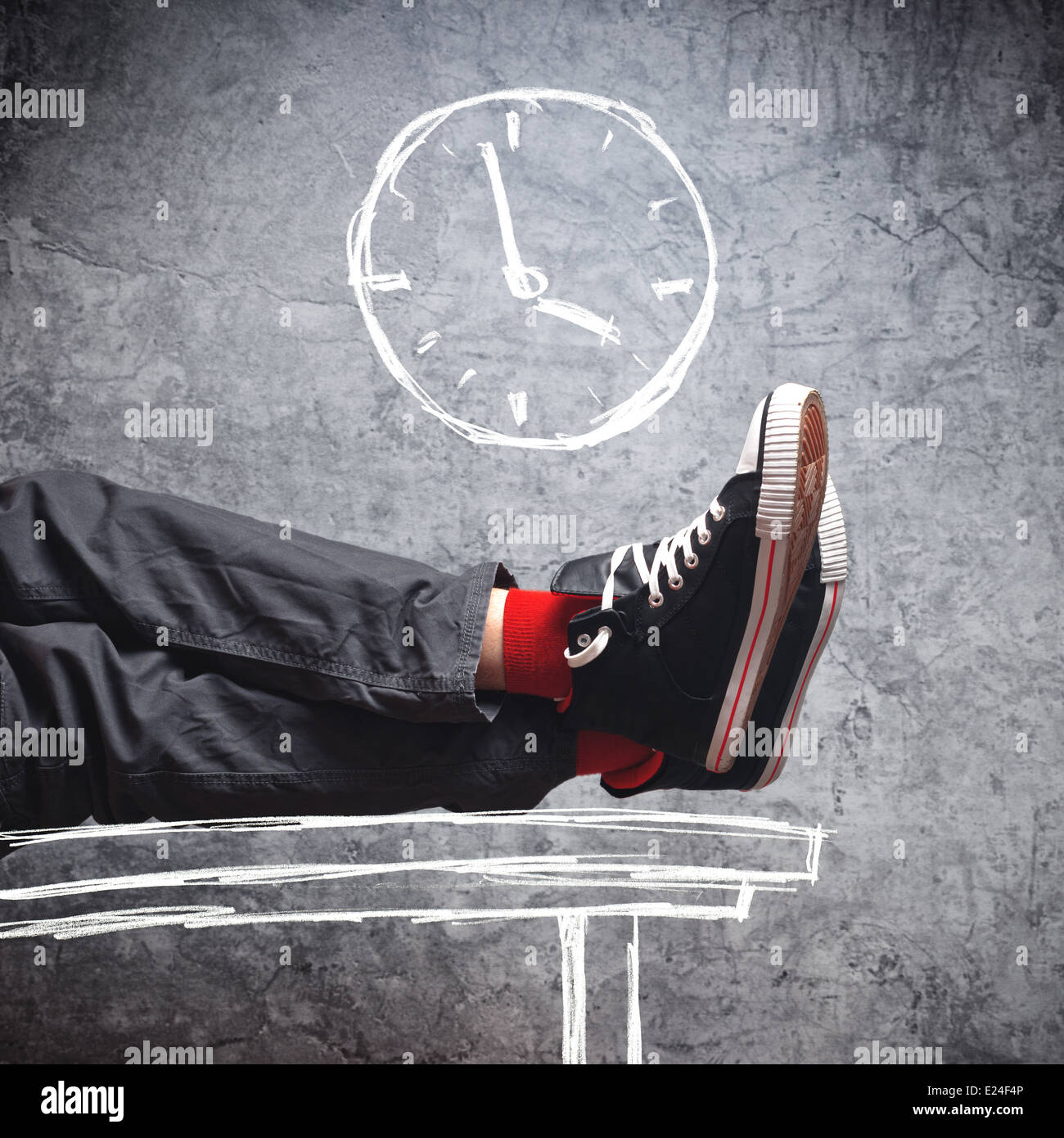Workday end. Lazy man in sneakers with his legs on the table, few minutes till the end of his working hours. Stock Photo