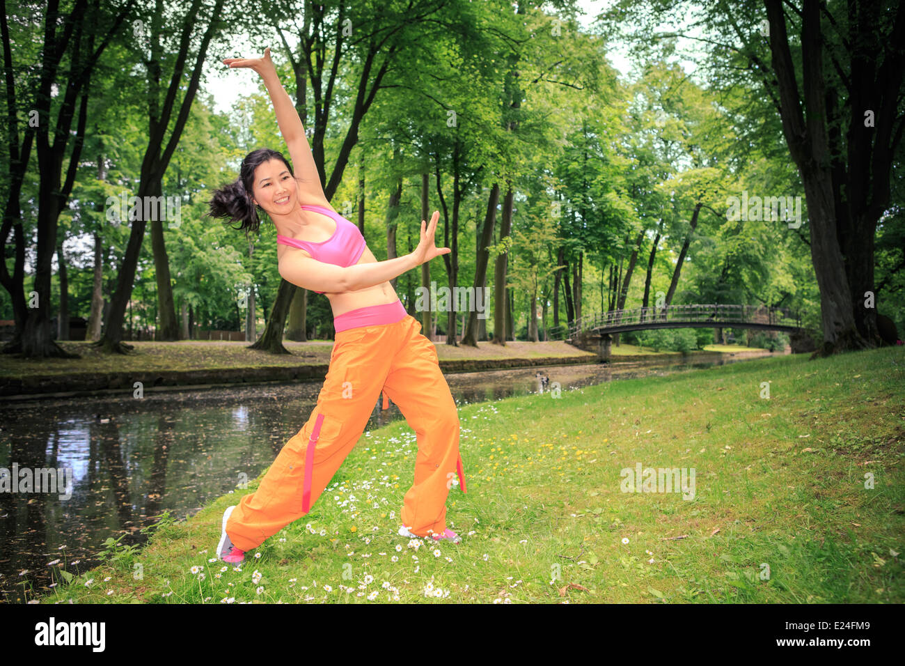 woman dancing zumba or aerobics in an old park Stock Photo