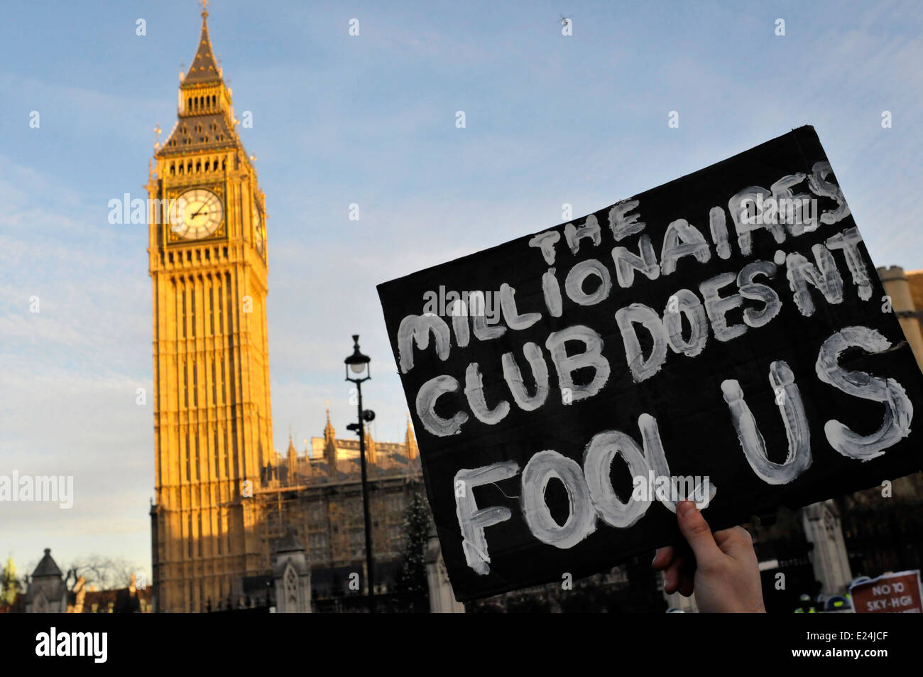 A student holds a placard in front of the parliament, reading 'the millionaires club does not fool us' Stock Photo