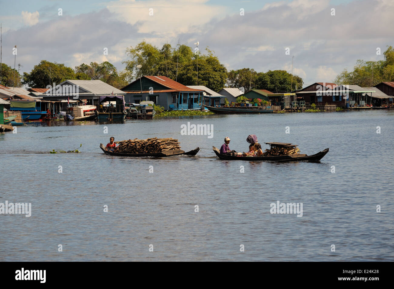 Family transporting firewood by small boat on the tonle sap lake Stock Photo