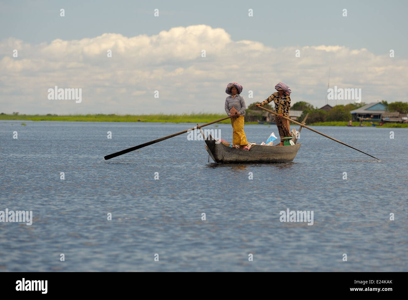 Two ladies rowing a boat standing up, Tonle Sap Lake Stock Photo