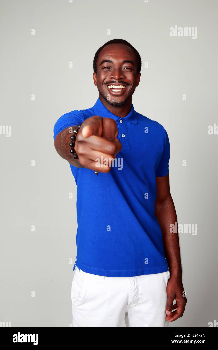 Laughing african man pointing at you on gray background Stock Photo