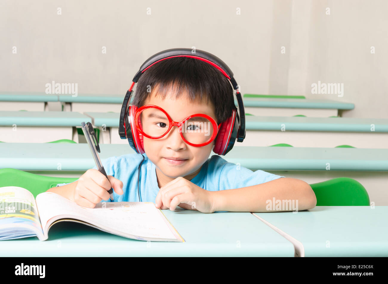 Smart student writing and wearing headphone Stock Photo