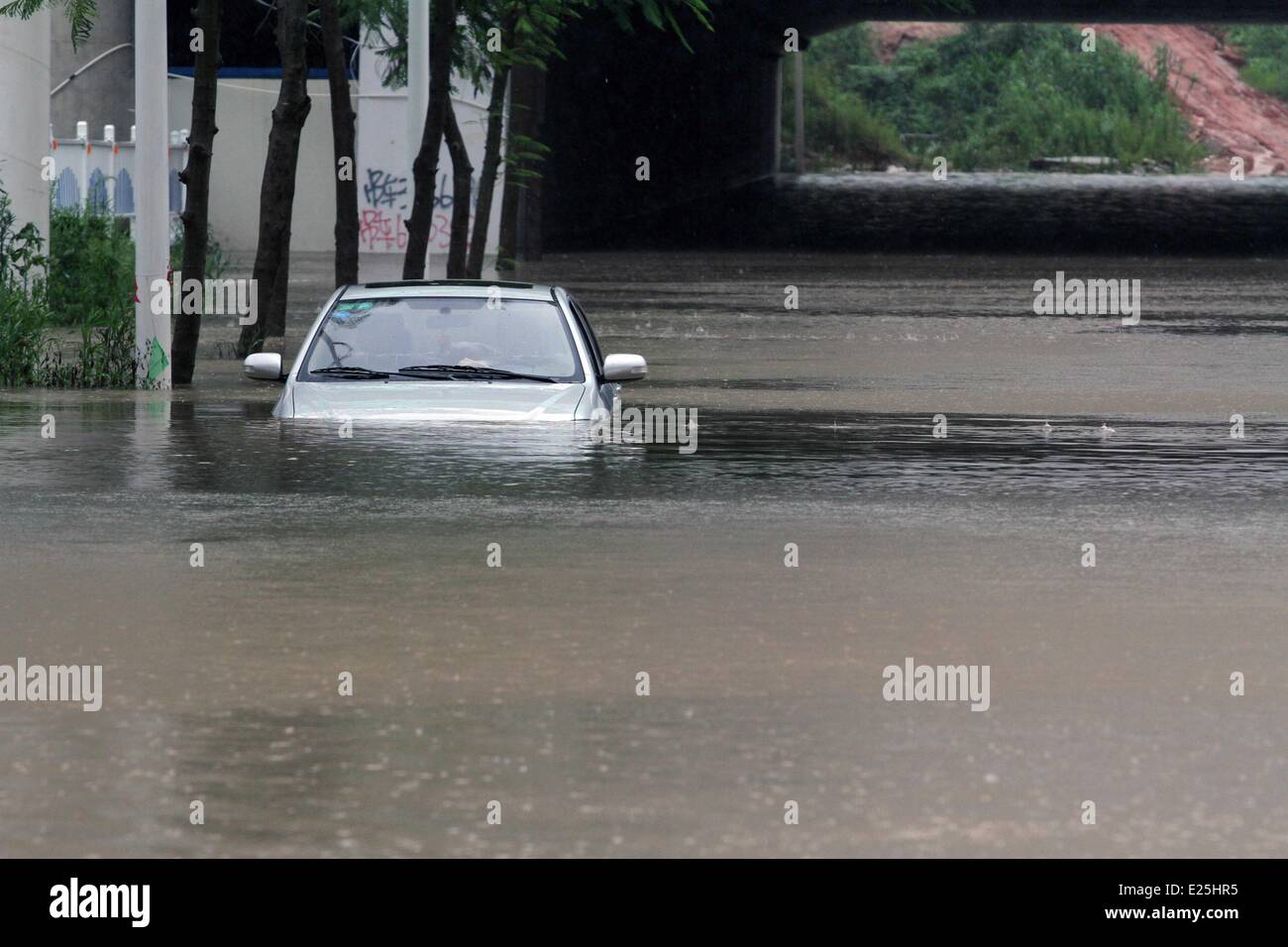 Xiamen, China's Fujian Province. 16th June, 2014. A vehicle lies submerged in water on a flooded street in Jimei District of Xiamen, southeast China's Fujian Province, June 16, 2014. Torrential rain hit Xiamen and four other cities in Fujian after typhoon Hagibis made its landfall in Shantou of the neighbouring Guangdong Province on Sunday night. Credit:  Zeng Demeng/Xinhua/Alamy Live News Stock Photo